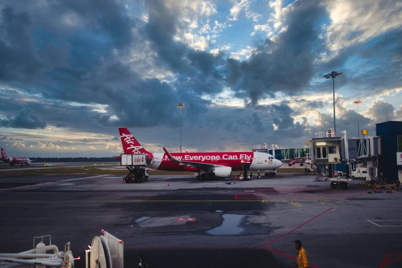 this airliner is parked on the tarmac with dark clouds