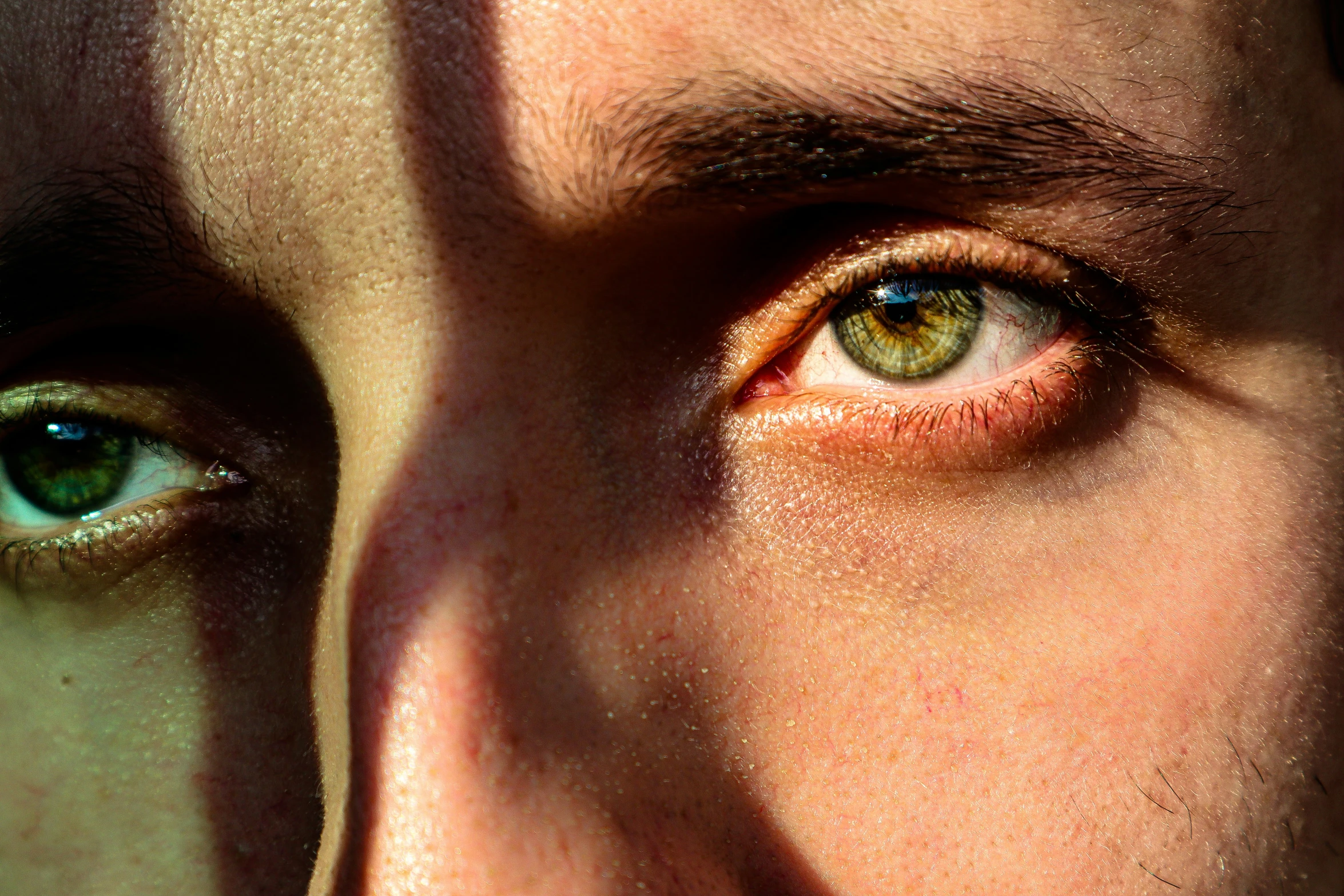 a close up of a persons eye with one green eye and the other a yellow eye
