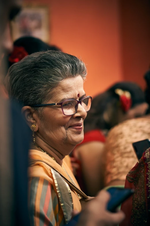 a woman in glasses sitting in a room