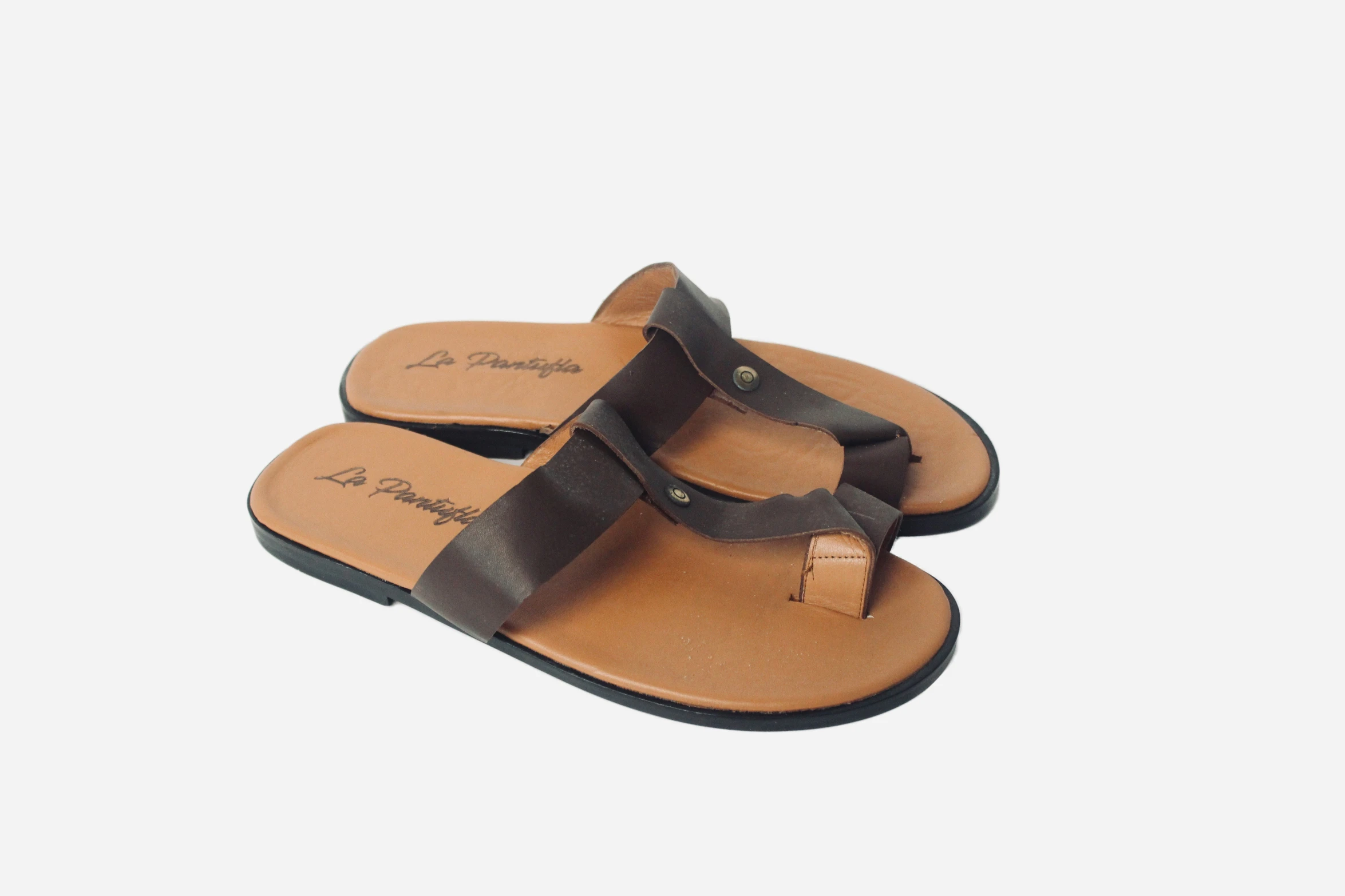 a brown sandals is sitting on a white surface