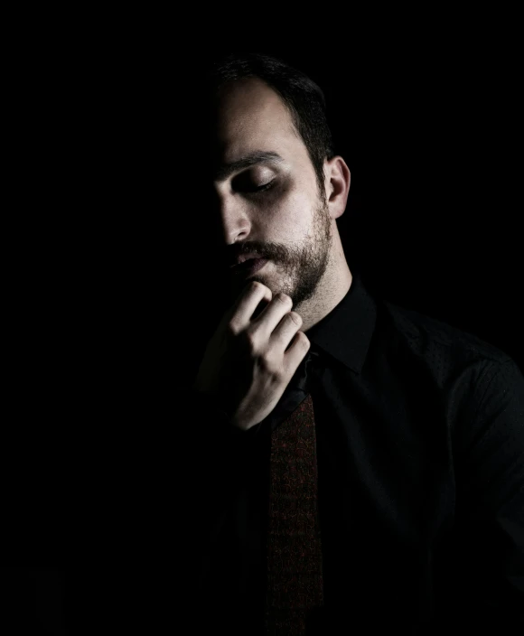 a man in a black shirt and brown tie