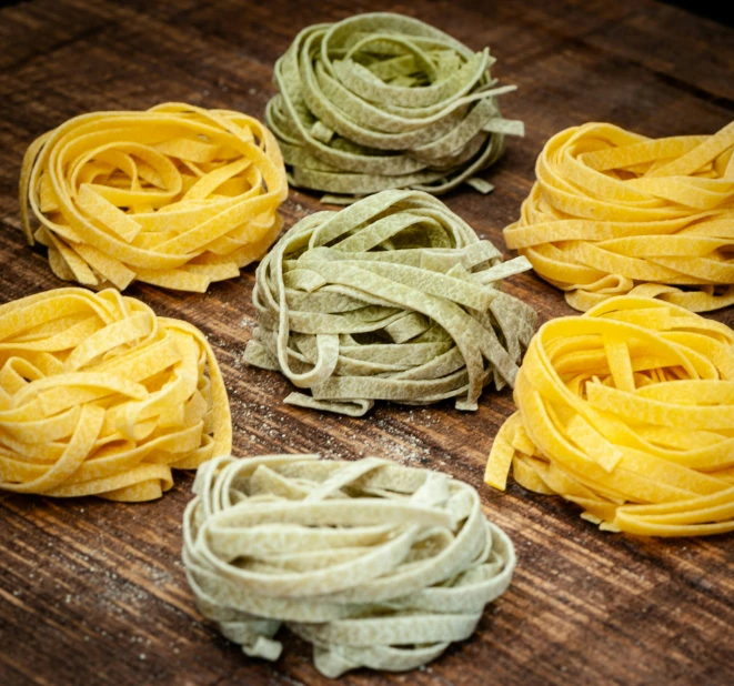 some small pieces of raw pasta on a wood surface