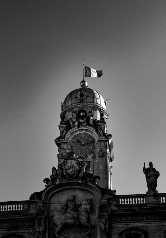 a tall building with a large clock and an american flag on top