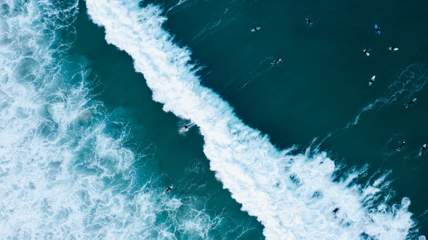 two waves in the ocean with surfers in it