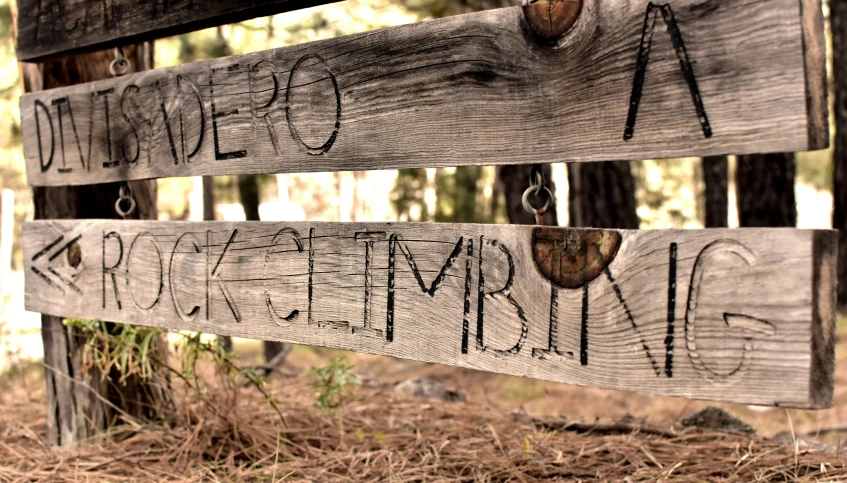 a close up of wooden signs on a fence