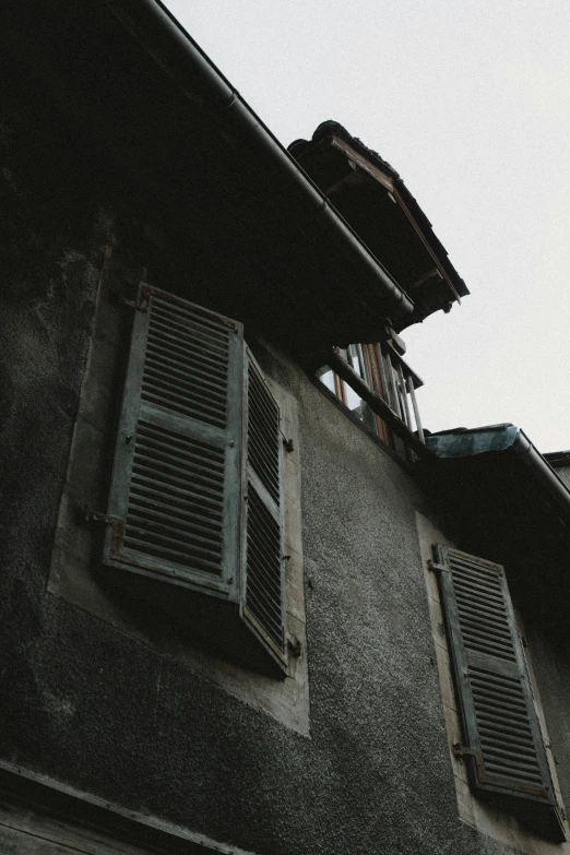 two windows that are on the side of an older building