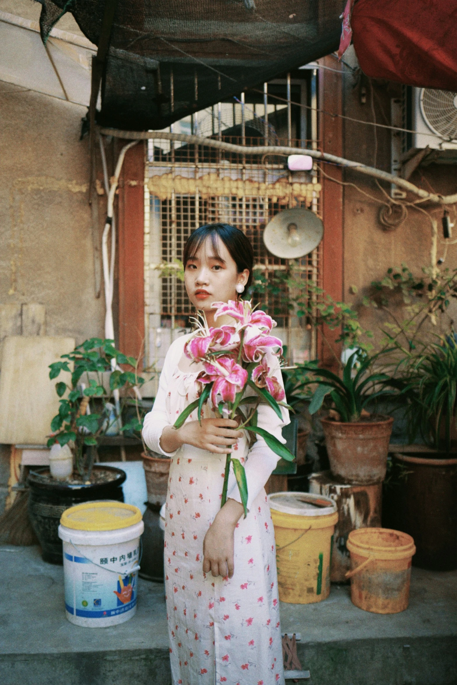 a woman standing on a porch holding flowers