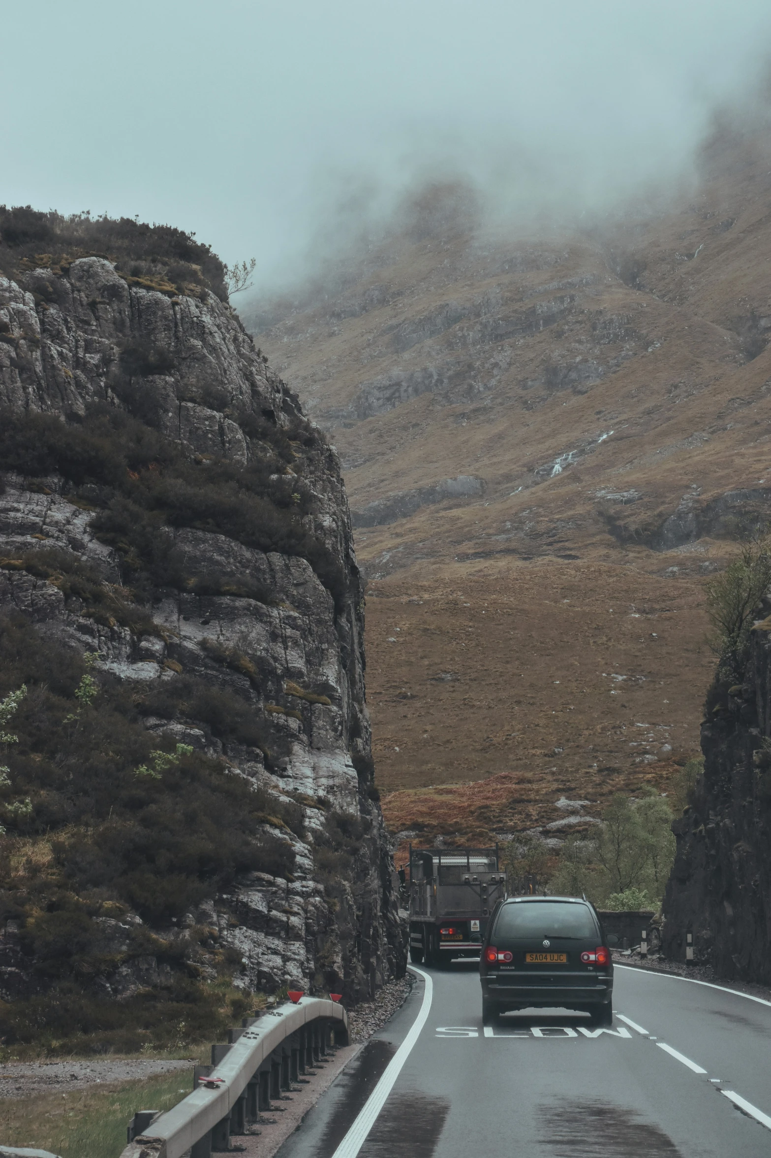 vehicles driving through a mountain pass in the mountains