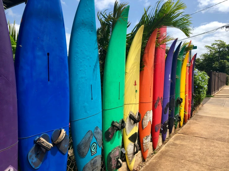 seven surfboards are lined up in front of a building