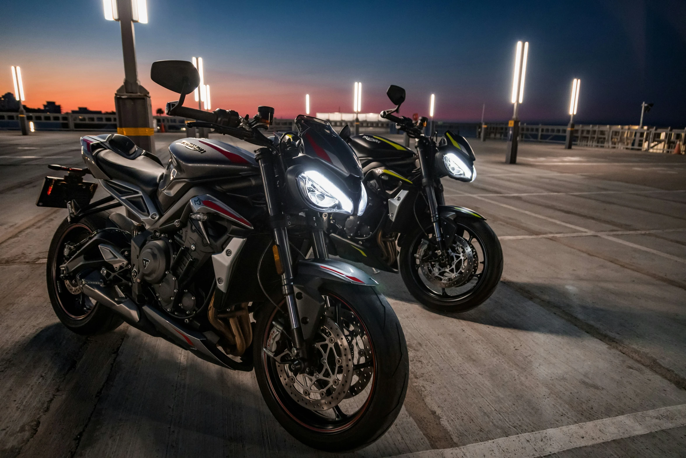 two motorcycles parked in a parking lot at night