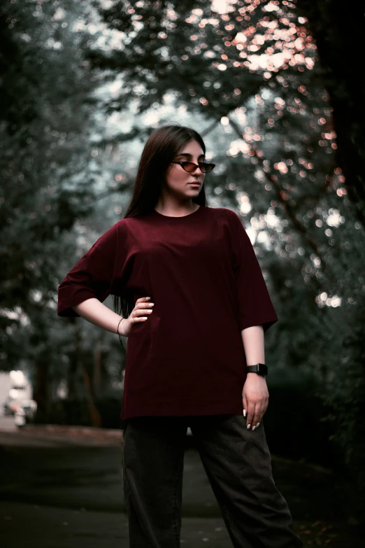 a girl is posing on the sidewalk in the park