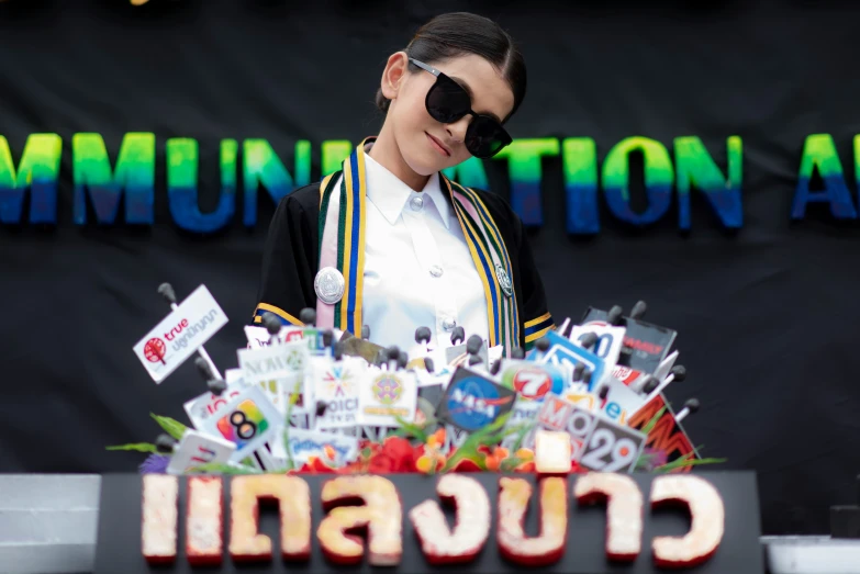 a woman with sun shades smiles next to an assortment of candies