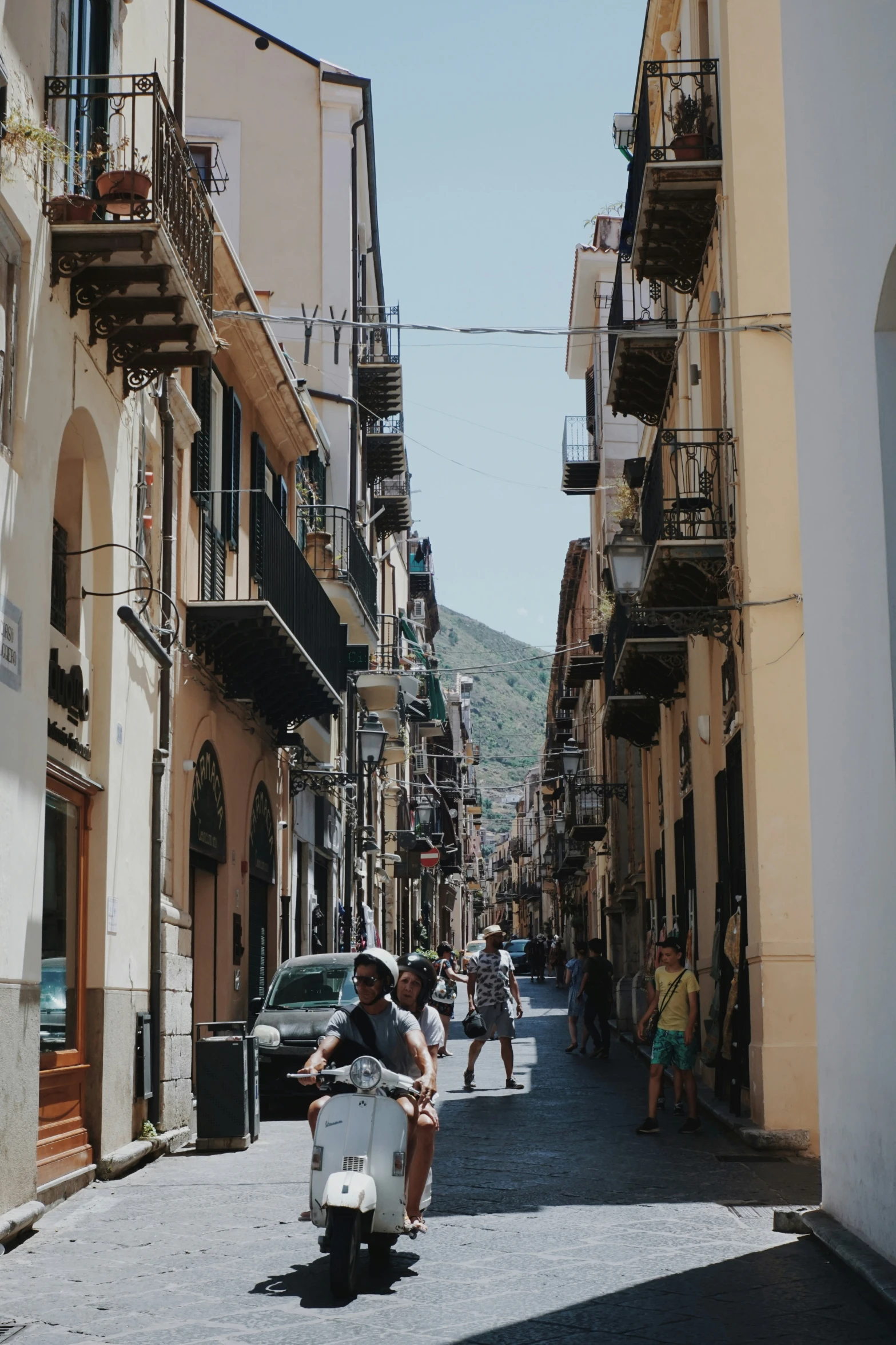 a man driving a scooter down a street