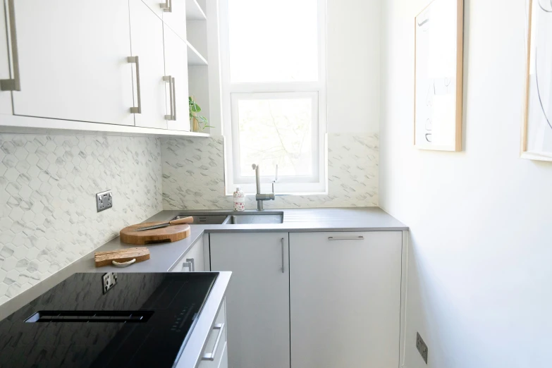 the kitchen with white cabinets has black counter tops