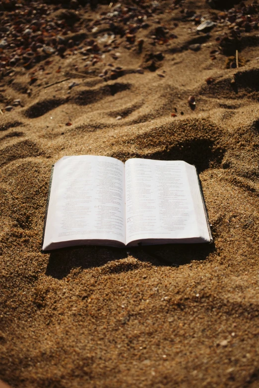 an open book in the sand on the beach