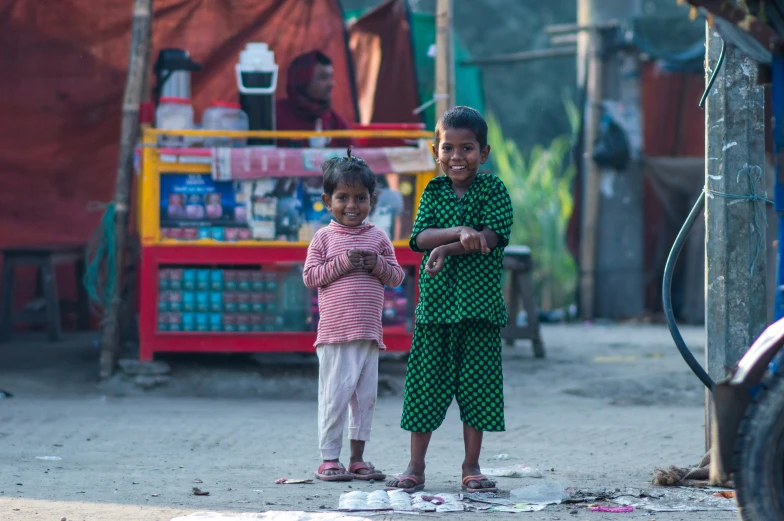 two young children standing in front of a red truck