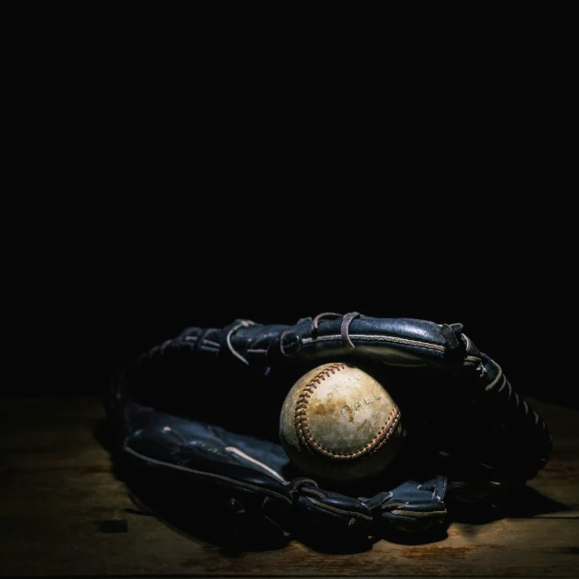 a catchers mitt with a baseball inside it on a table