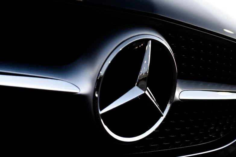 the mercedes benz emblem is displayed on the front grille