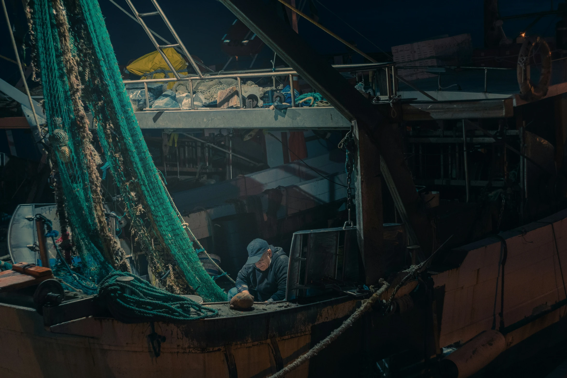 two people working on a sailboat in the sea