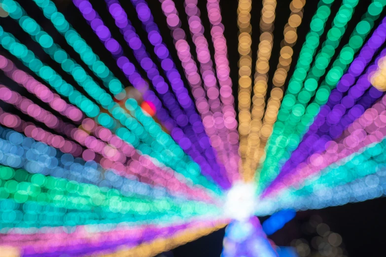 colorful string lights decorate a brightly colored ferris wheel