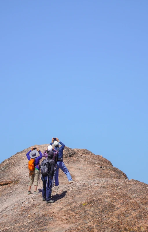 a group of people standing on top of a rocky hill