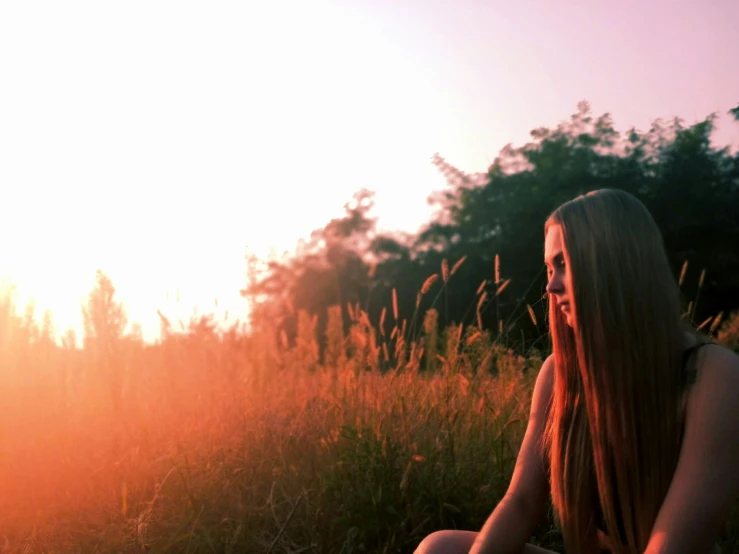 a beautiful young woman in a field looking into the distance