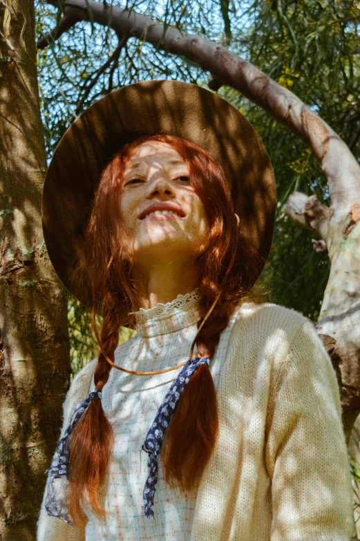 a girl with red hair wearing a brown hat and blue ties