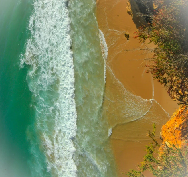 an aerial view of a beach and ocean next to a sandy shore