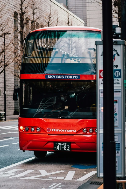 a red double decker bus stopped at a crosswalk