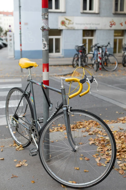 bicycle parked on side of city street with yellow rims