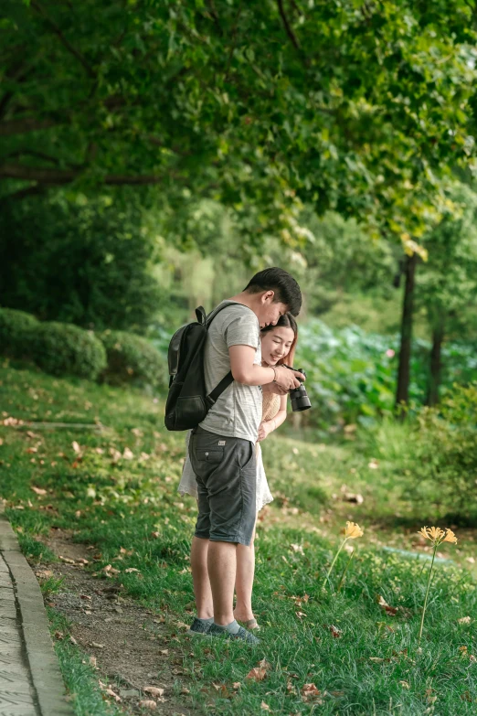 a couple of people standing on a grass covered street