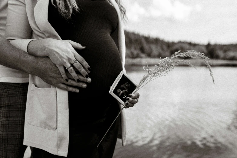 a pregnant woman standing next to a mans belly