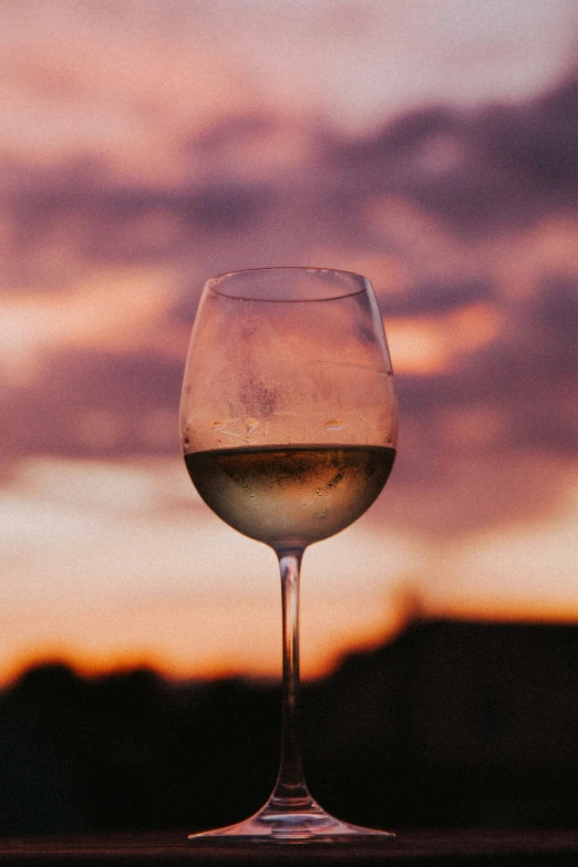 wine glass on a wooden table at sunset