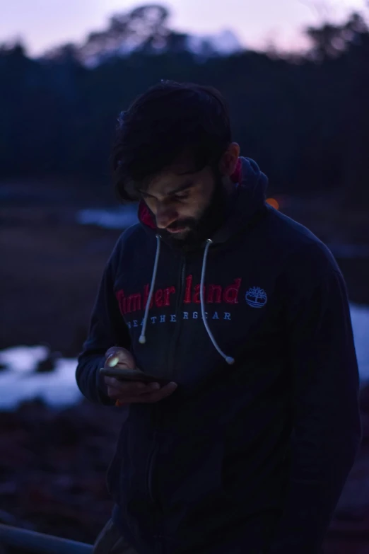 a man using a cell phone near some water