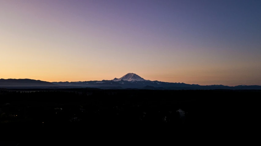 the silhouette of mountains at sunset