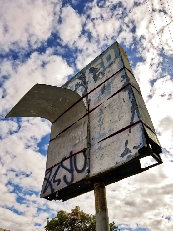 a rusted sign with the word ouka written on it