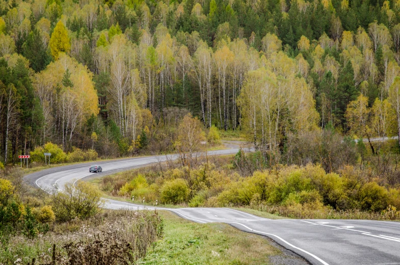 two vehicles driving on an empty country road