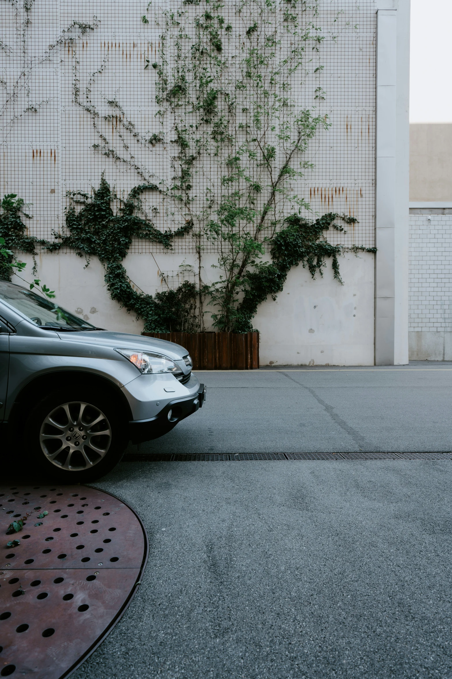 a small silver car parked in front of a white building