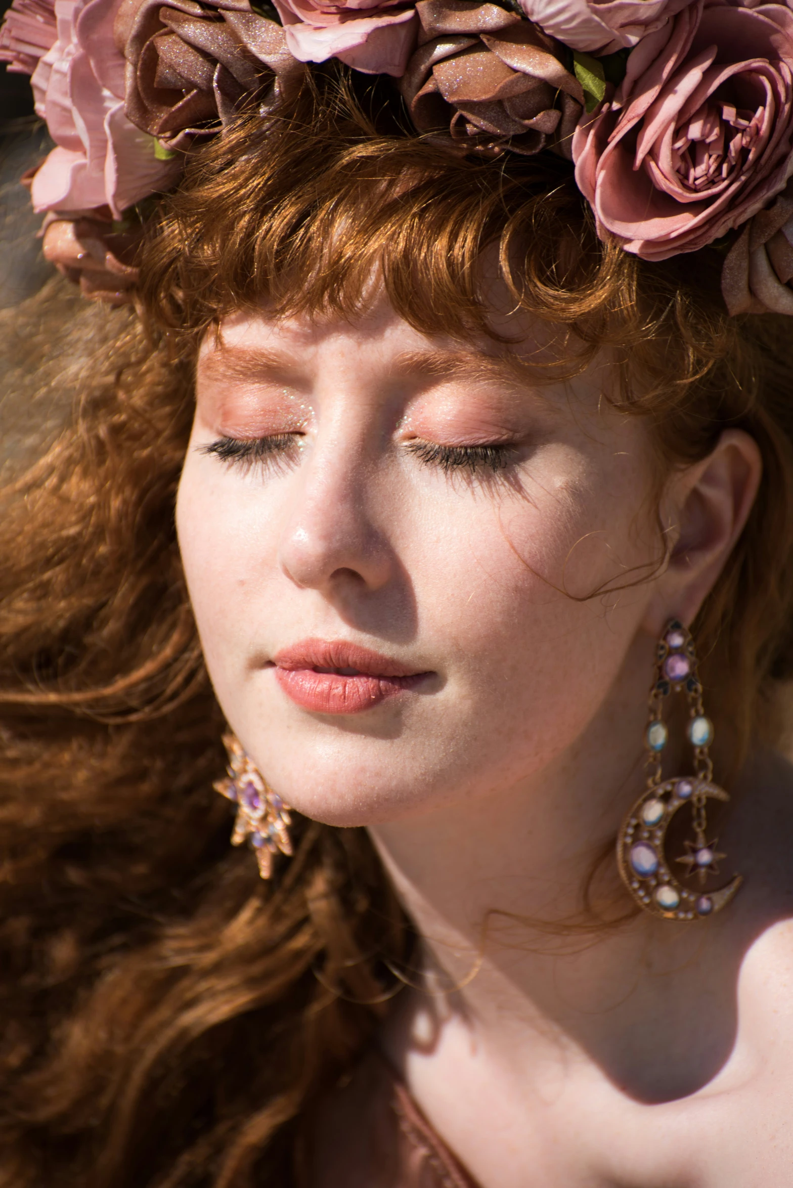 a beautiful young red haired girl in a flower head wreath