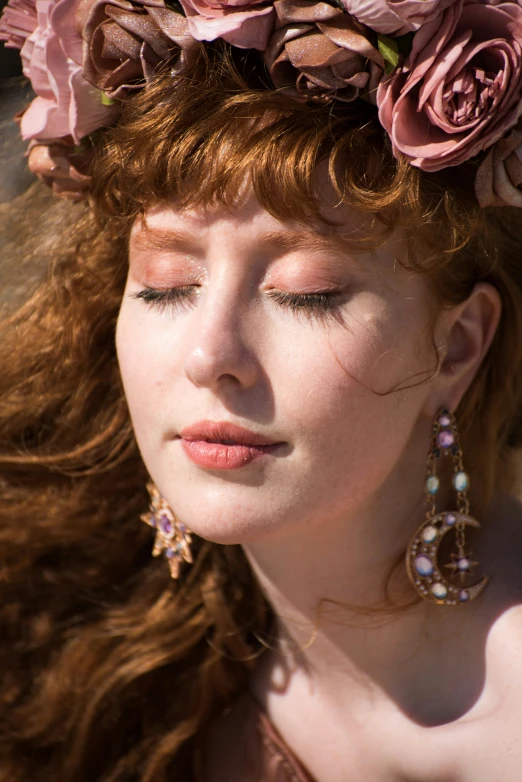 a beautiful young red haired girl in a flower head wreath