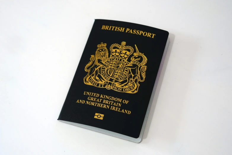 a british passport sitting on a white surface