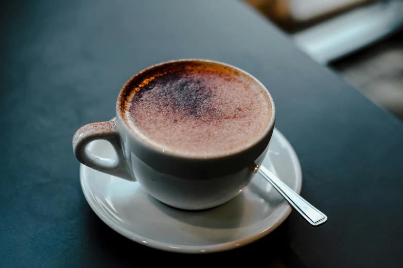 a cup filled with  chocolate on top of a saucer