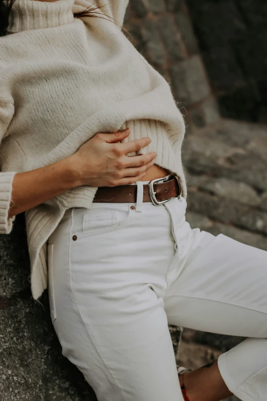 a woman in white jeans and a sweater