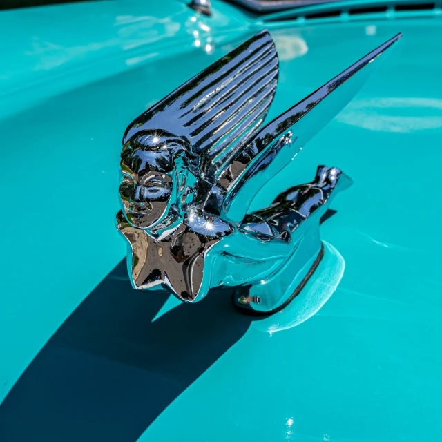 chrome winged object on shiny blue car at show