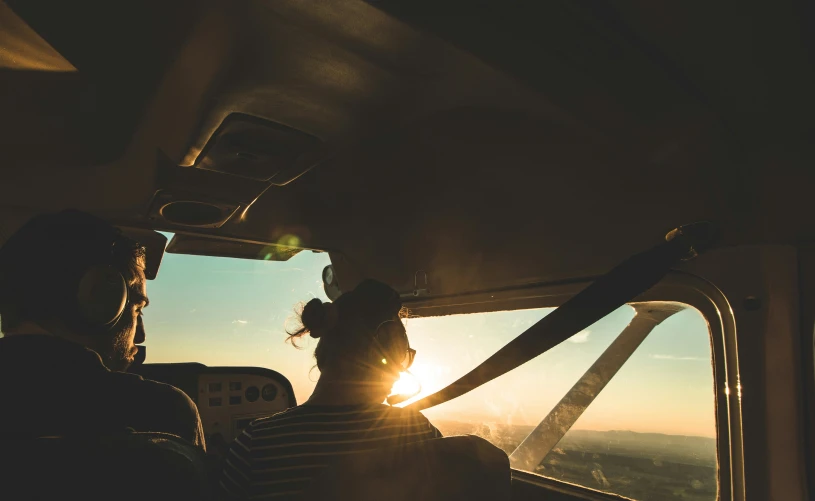 the people are looking out the window of an airplane