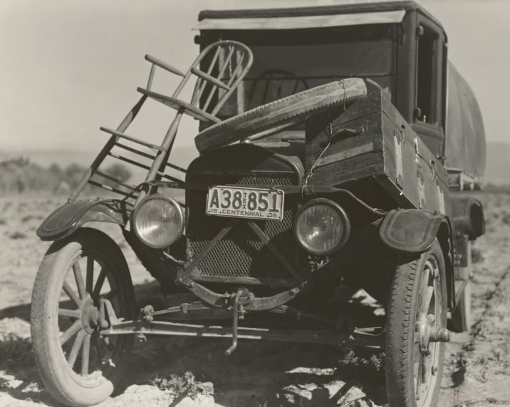 an old black and white po of a car on a dirt field