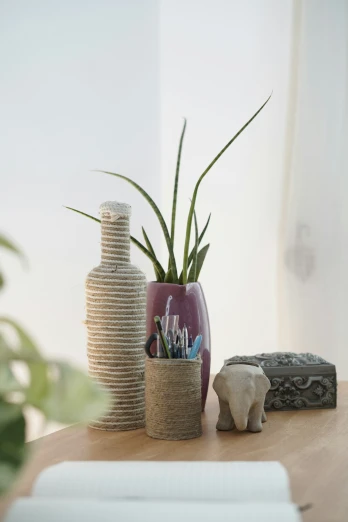 a elephant sculpture and a plant are on the wooden table
