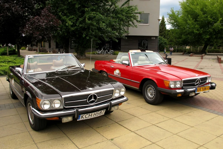 two vintage cars are parked next to each other on the street