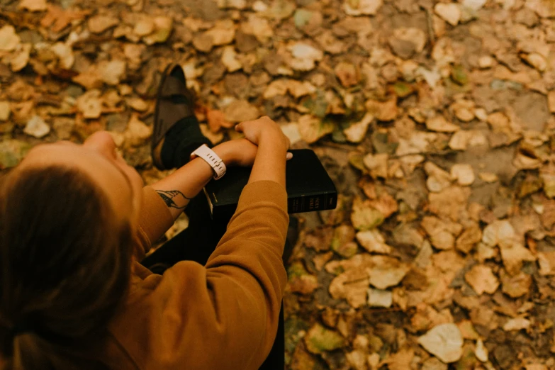 a person is standing in the leaves with their feet on their cell phone