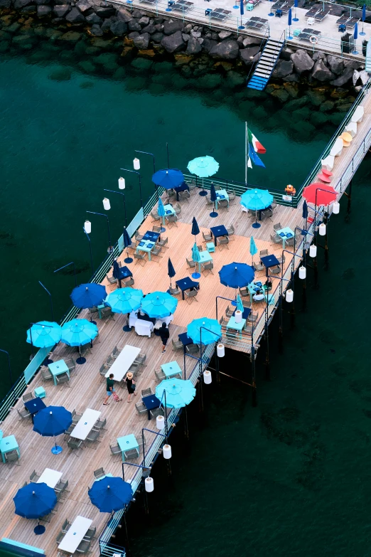 an elevated view of chairs and umbrellas set up on a dock